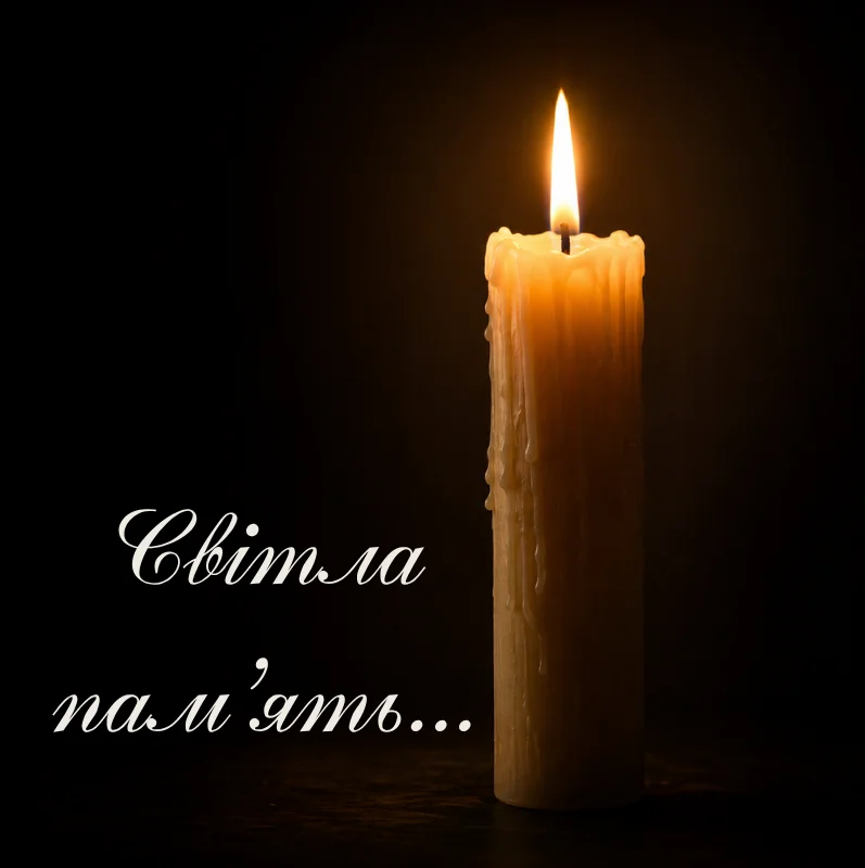 Запалена свічка на чорному фоні зі словами світла пам’ять
