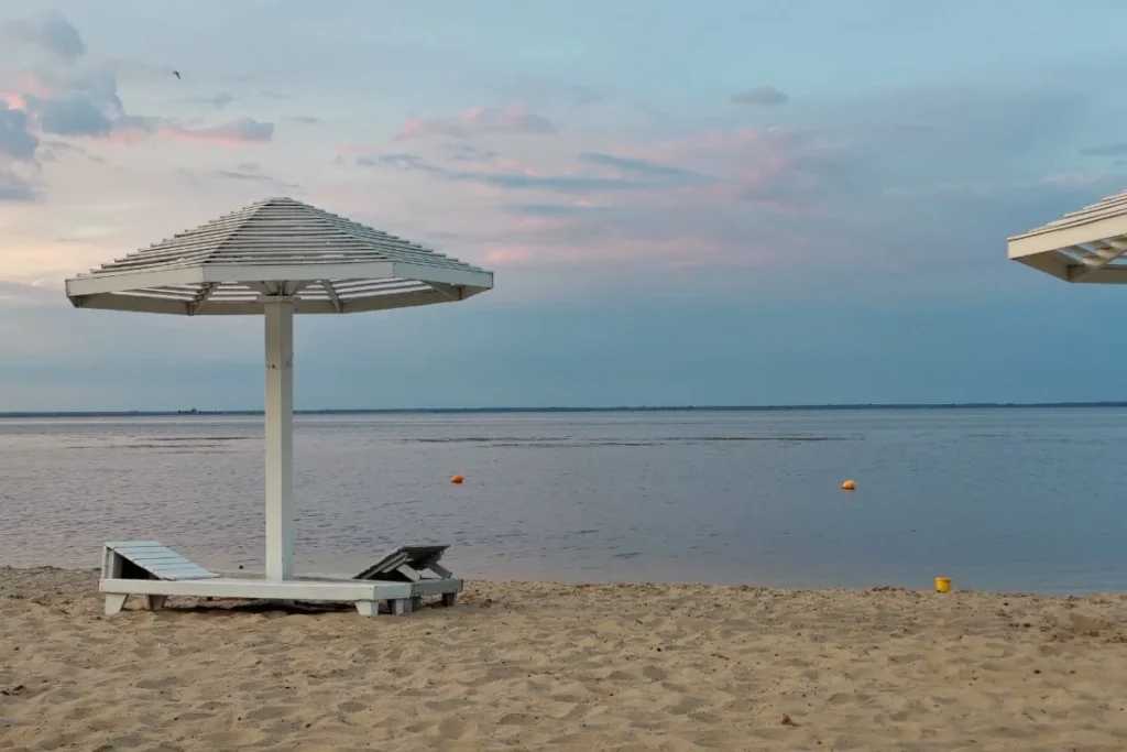 Піщаний пляж Кременчуцького водосховища із парасолькою біля води 
